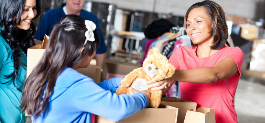 Woman giving a teddy bear to a child